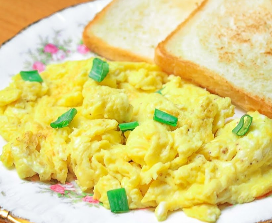 scrambled eggs with with bread and onions as garnishing in a plate for weight management